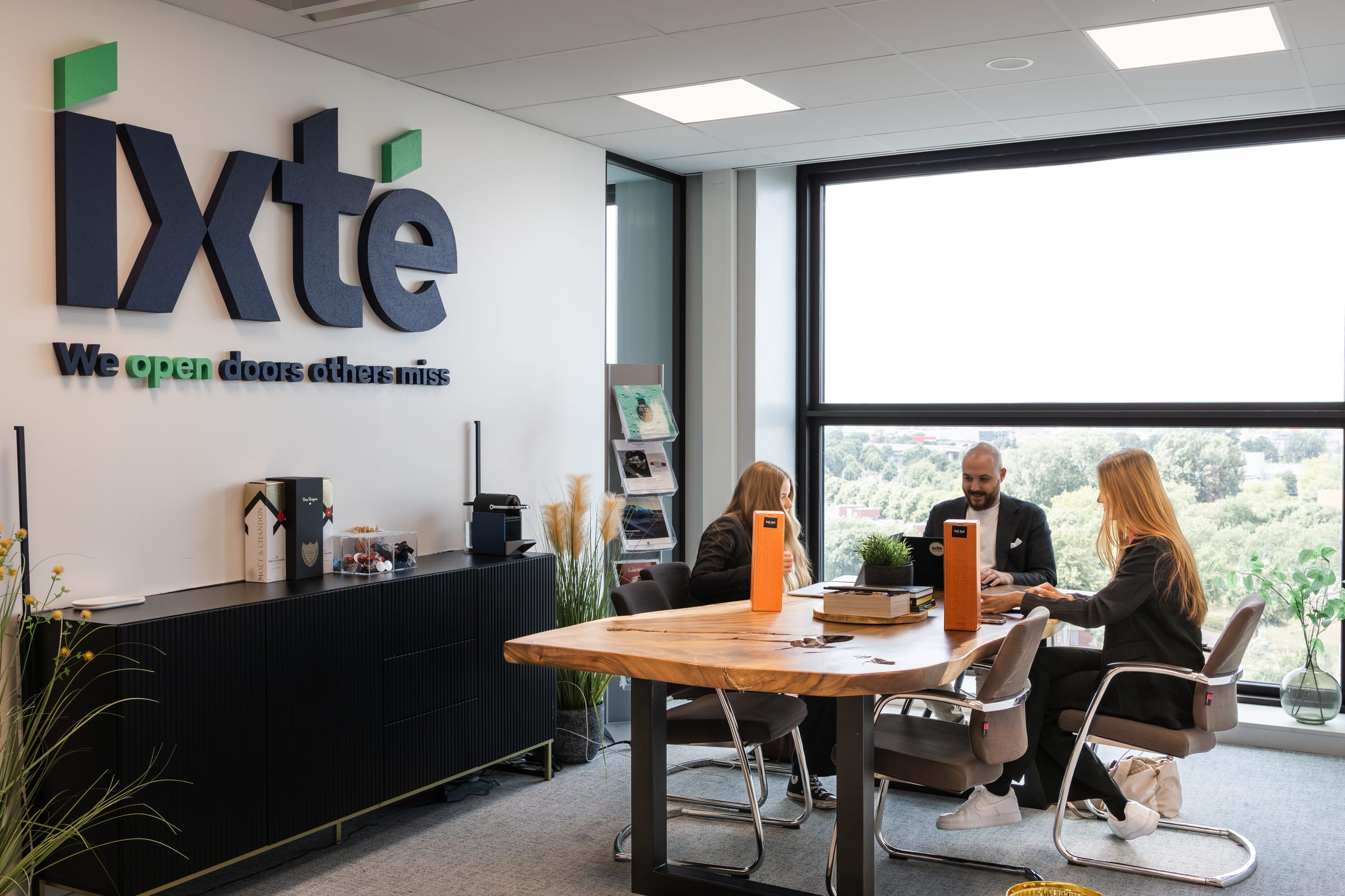 Teamoverleg aan tafel onder het IXTE-logo
