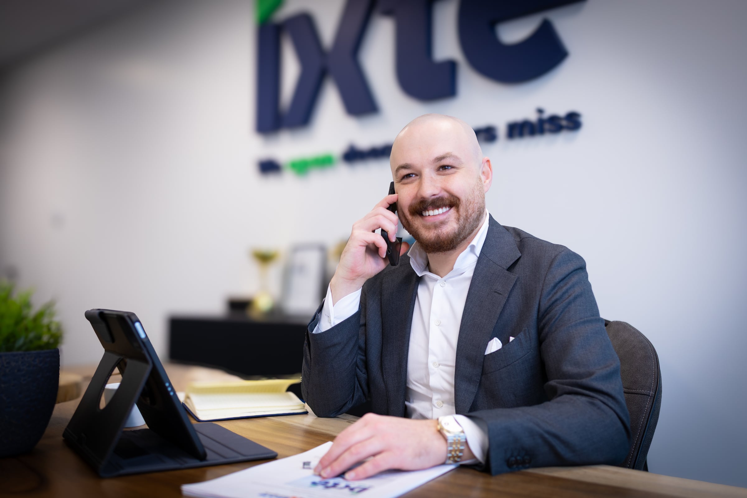 Ilya Popyuk, Managing Director van IXTE, aan de telefoon voor de merkwand op kantoor