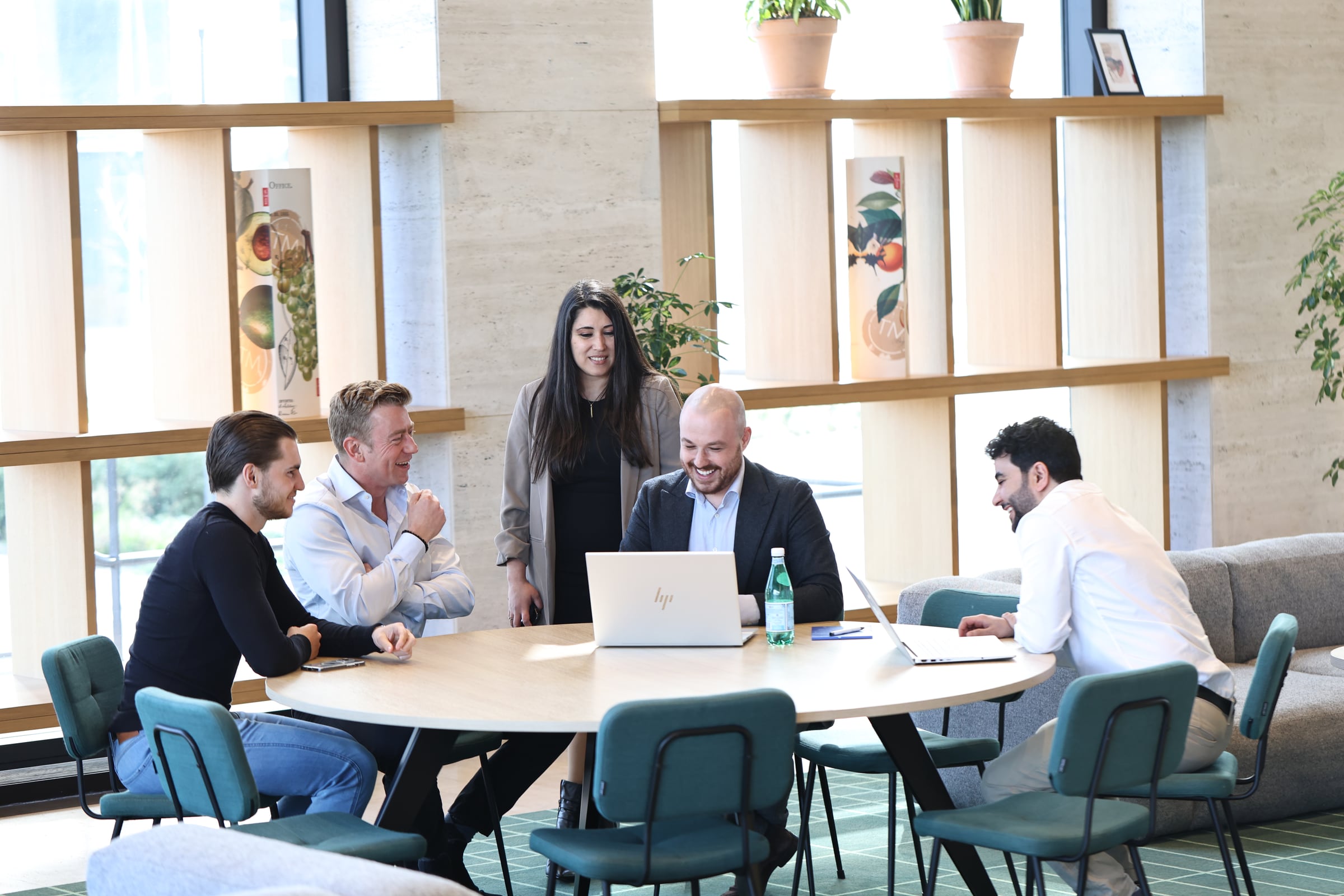 Het team van IXTE in overleg rond een tafel op kantoor