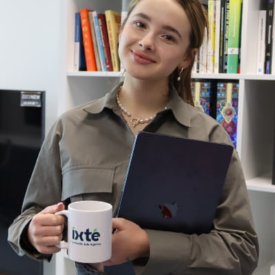 Medewerker van IXTÉ met een IXTÉ-mok en een laptop